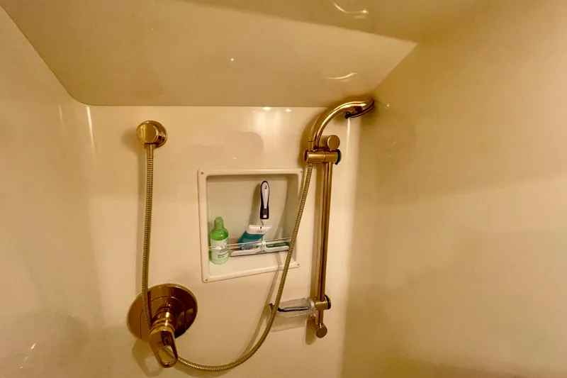 Slide: The Image of Shower area in 2005 Viking 48 Convertible yacht with gold fixtures and toiletries. - 20