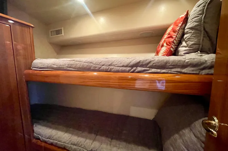 Slide: The Image of Bunk beds in 2005 Viking 48 Convertible yacht cabin with wooden finish and cozy bedding. - 22
