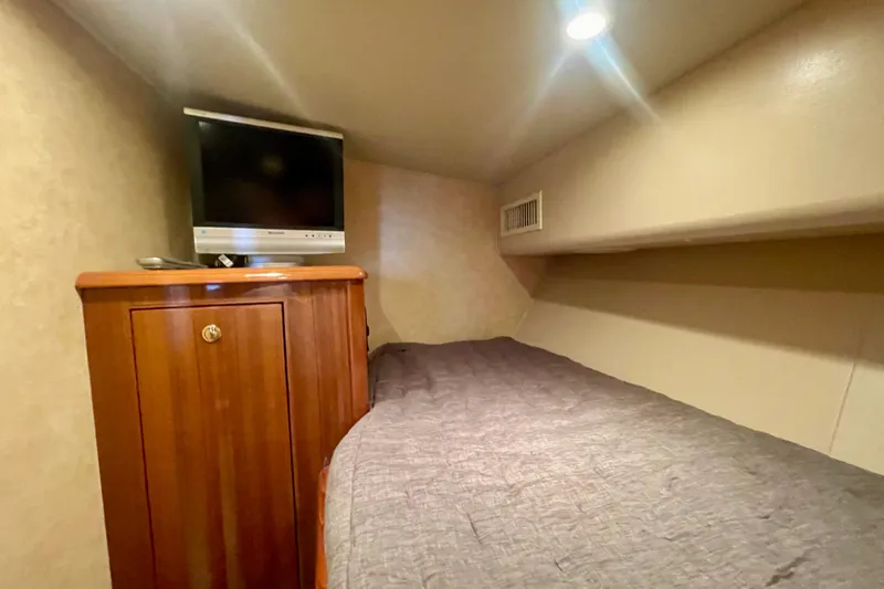 Slide: The Image of Cozy cabin interior of 2005 Viking 48 Convertible with TV and wooden cabinet. - 23