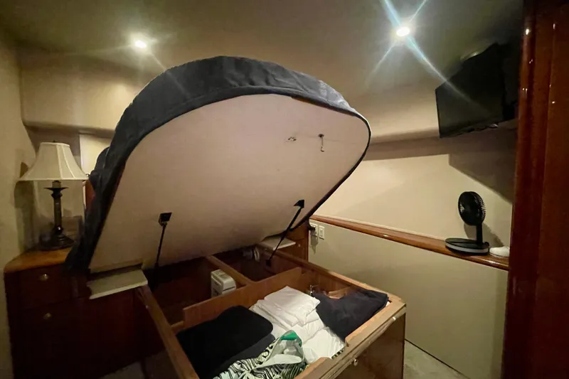 Slide: The Image of Interior of 2005 Viking 48 Convertible yacht with raised bed storage and modern amenities. - 24