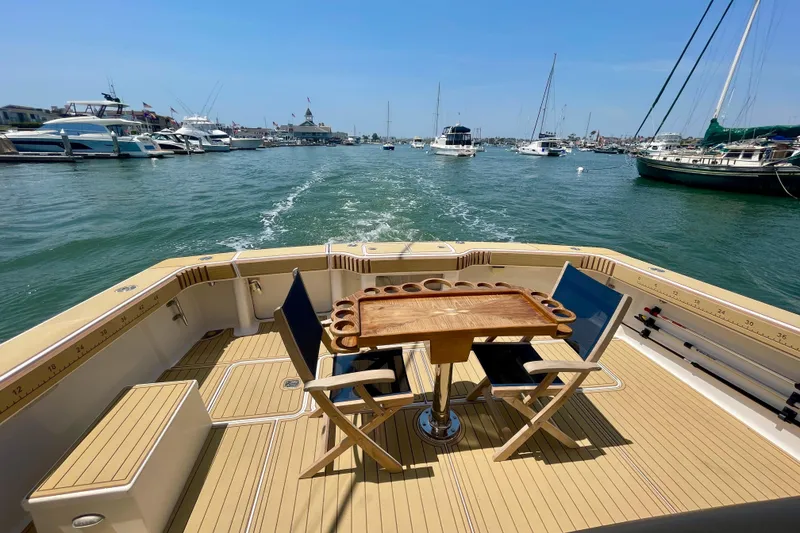 Slide: The Image of 2005 Viking 48 Convertible yacht with deck chairs and table, cruising in a marina. - 25