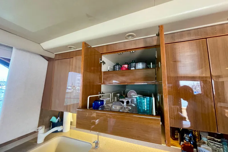 Slide: The Image of Open kitchen cabinet in 2005 Viking 48 Convertible yacht, showcasing organized glassware and containers. - 28