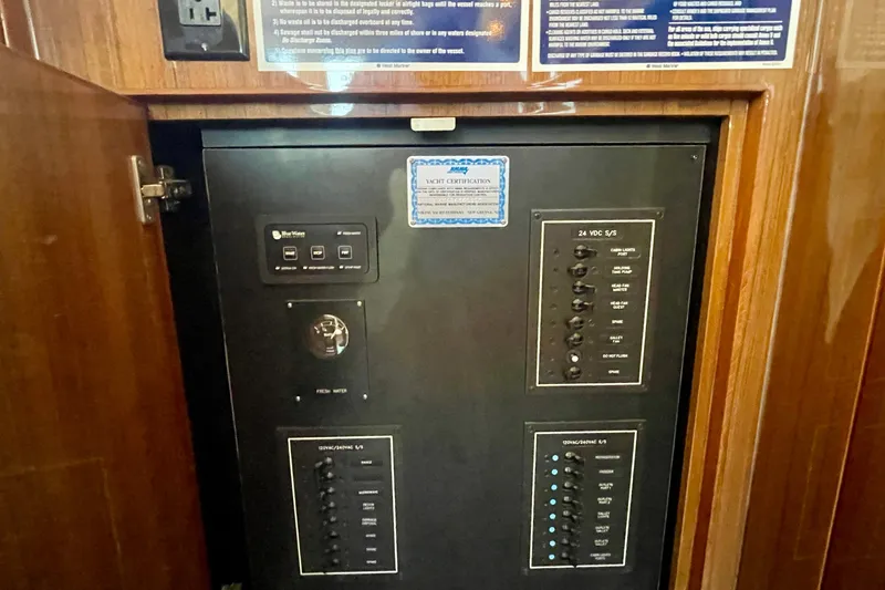 Slide: The Image of Electrical panel inside 2005 Viking 48 Convertible yacht, featuring control switches and certification label. - 29