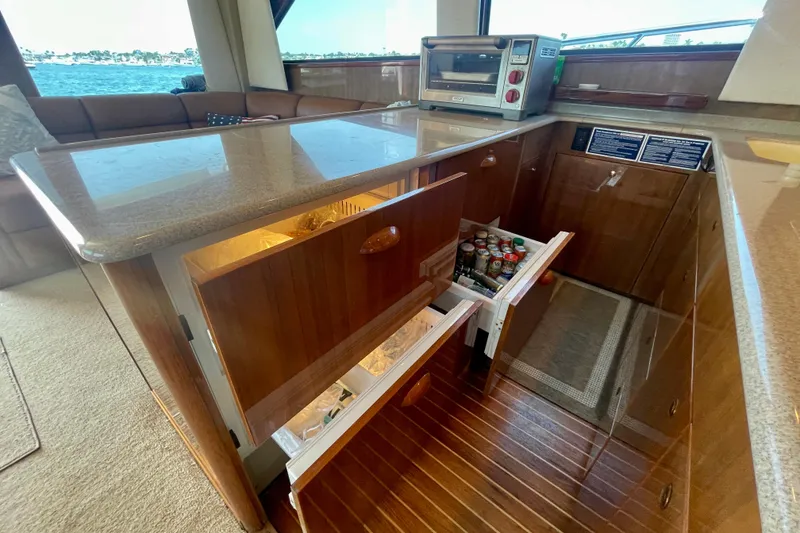 Slide: The Image of Luxurious 2005 Viking 48 Convertible yacht kitchen with wooden cabinetry and modern appliances. - 35