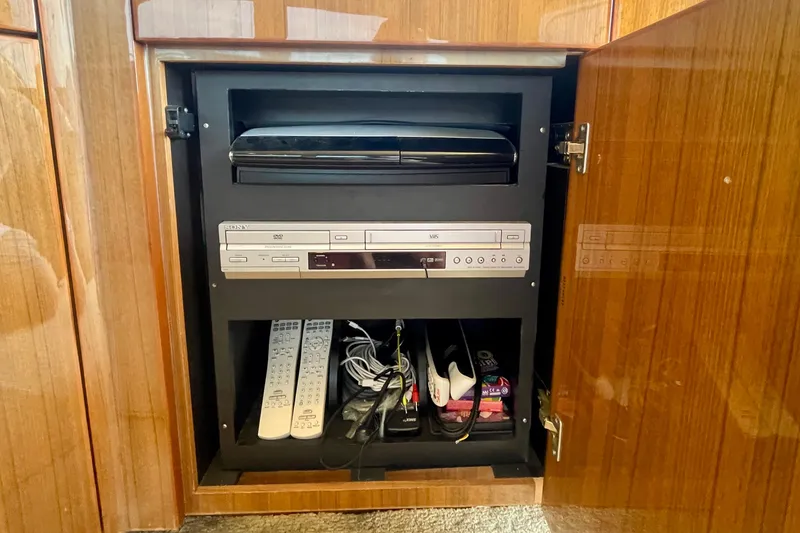 Slide: The Image of Entertainment cabinet in 2005 Viking 48 Convertible yacht with DVD player and remotes. - 38