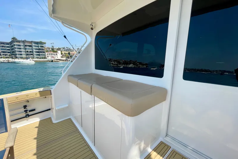 Slide: The Image of 2005 Viking 48 Convertible yacht deck with seating, overlooking marina and waterfront buildings. - 50