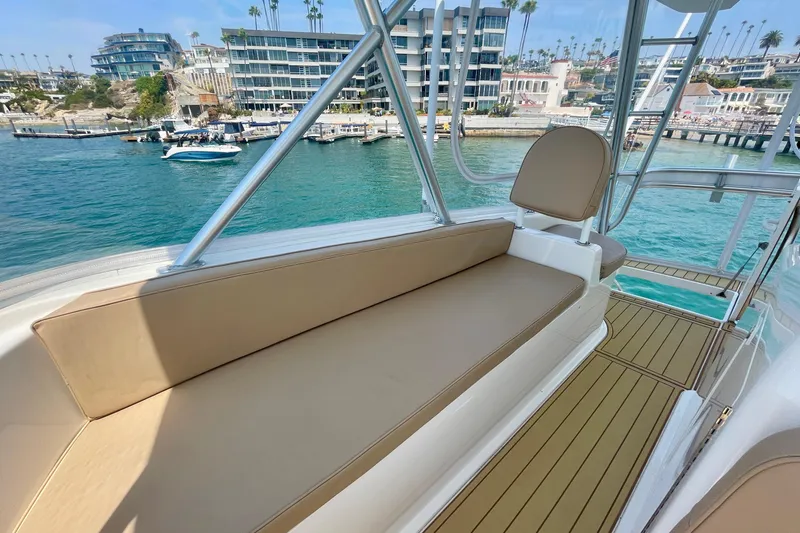 Slide: The Image of 2005 Viking 48 Convertible yacht interior with waterfront view, featuring beige seating. - 63