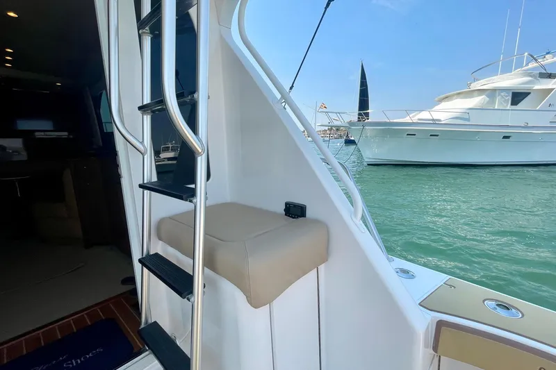 Slide: The Image of 2005 Viking 48 Convertible yacht with ladder, docked near another boat. - 73