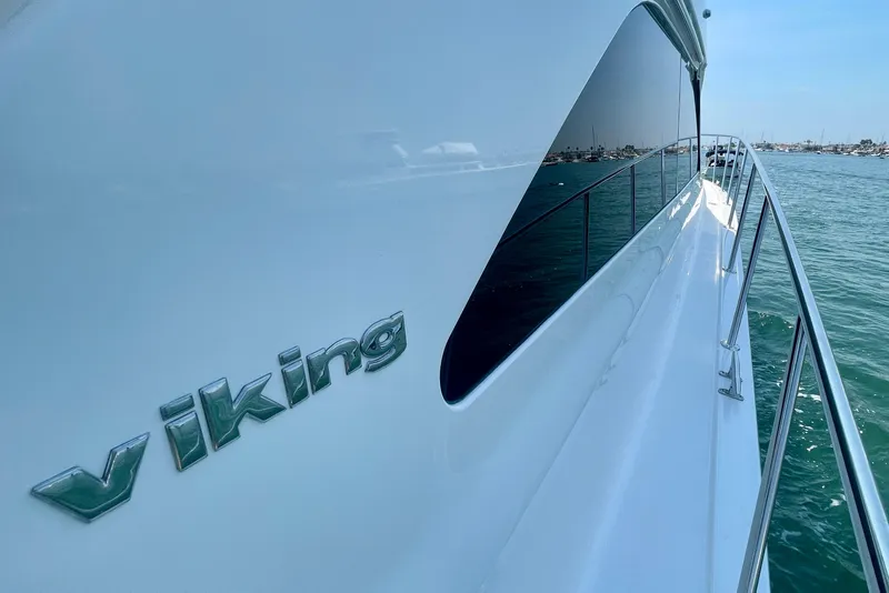 Slide: The Image of 2005 Viking 48 Convertible yacht, sleek design, docked on calm water. - 74