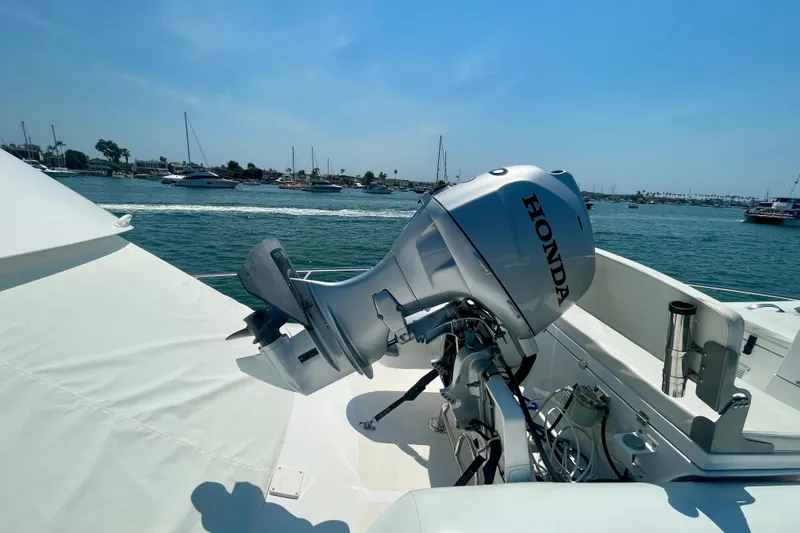 Slide: The Image of 2005 Viking 48 Convertible yacht with Honda outboard motor, docked in a marina. - 76