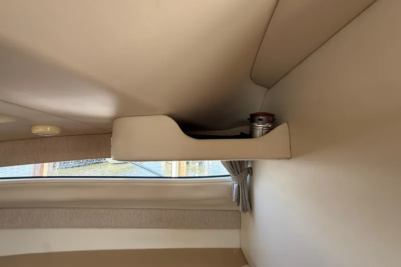 Slide: The Image of Interior of a 2004 Bayliner 285 boat with shelf and window view. - 10