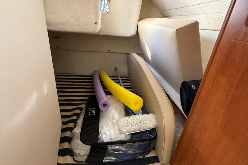 Slide: The Image of Interior cabin of 2004 Bayliner 285 with pool noodles and cleaning supplies. - 13