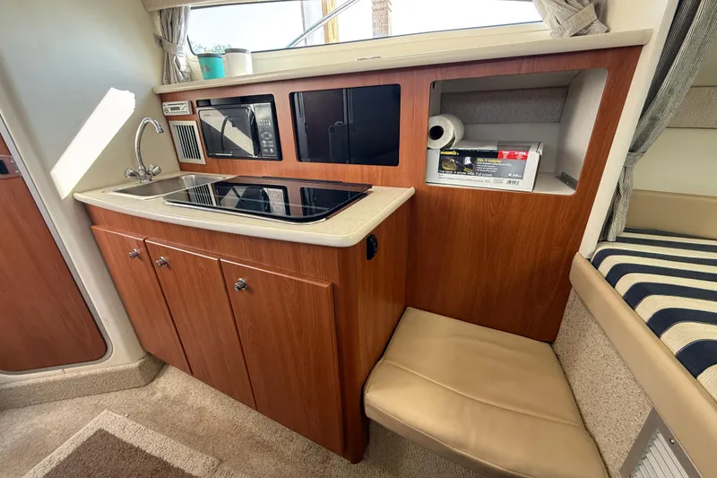 Slide: The Image of 2004 Bayliner 285 boat interior kitchen with sink, stove, and microwave. - 15