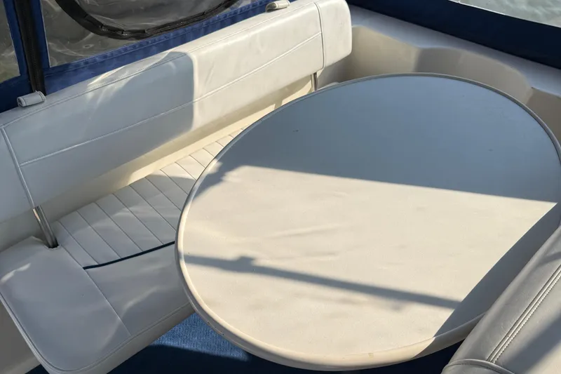 Slide: The Image of Interior seating area of a 2004 Bayliner 285 boat with oval table. - 17