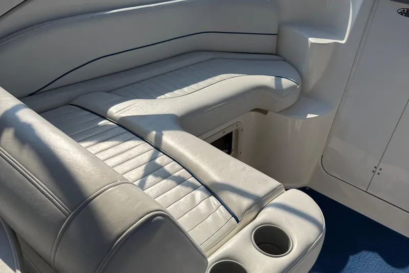 Slide: The Image of 2004 Bayliner 285 boat interior with white leather seating and cup holders. - 20