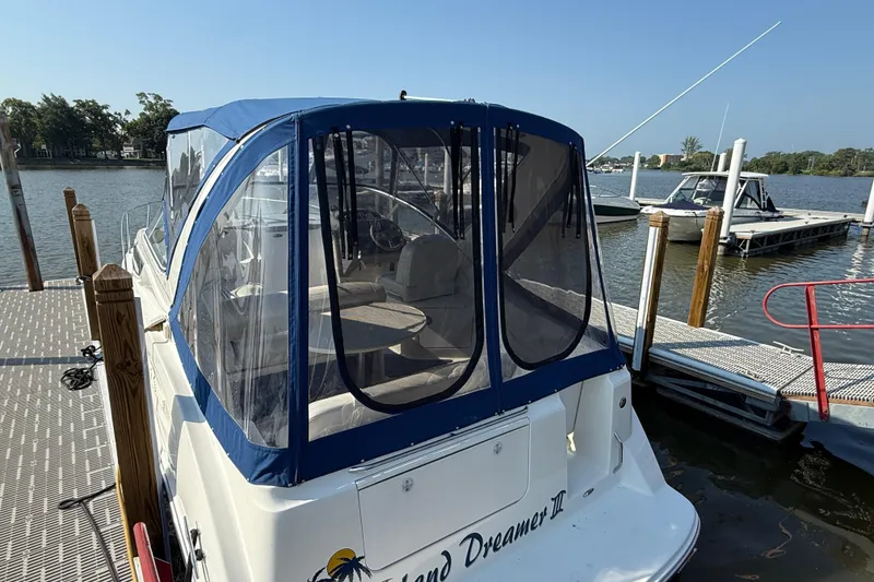 Slide: The Image of 2004 Bayliner 285 boat docked with blue canopy and clear windows. - 21