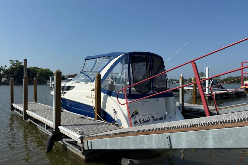 Slide: The Image of 2004 Bayliner 285 boat docked at marina under clear blue sky. - 3