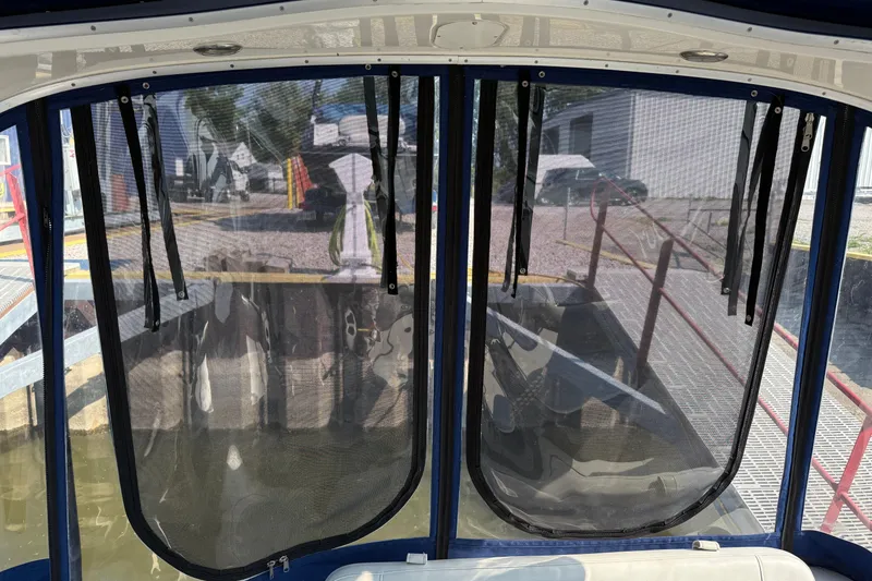 Slide: The Image of 2004 Bayliner 285 boat with mesh windows at a dockside view. - 7