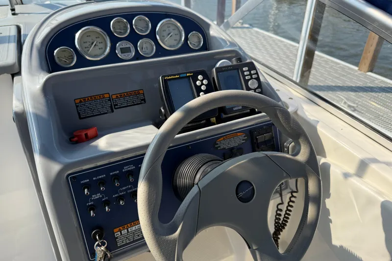Slide: The Image of 2004 Bayliner 285 boat dashboard with steering wheel and navigation instruments. - 8
