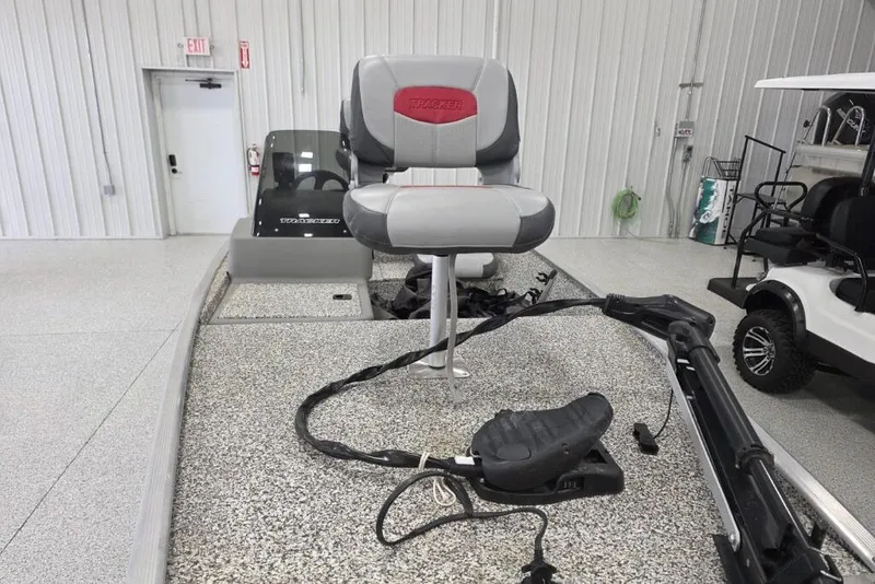 Slide: The Image of 2016 Tracker Pro 160 boat interior with seating and equipment in a showroom. - 2