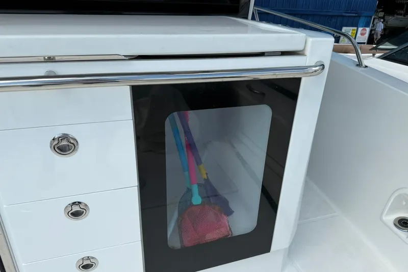Slide: The Image of 2024 Jeanneau Leader 10.5 CC boat interior with storage compartment and colorful items. - 24