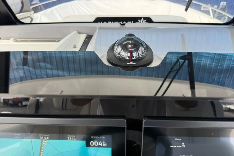 Slide: The Image of 2024 Jeanneau Leader 10.5 CC dashboard with compass and navigation screens. - 28