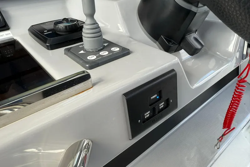 Slide: The Image of 2024 Jeanneau Leader 10.5 CC helm controls with throttle, steering, and ignition panel. - 32