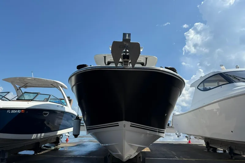 Slide: The Image of 2024 Jeanneau Leader 10.5 CC boat docked between two other boats under a blue sky. - 4