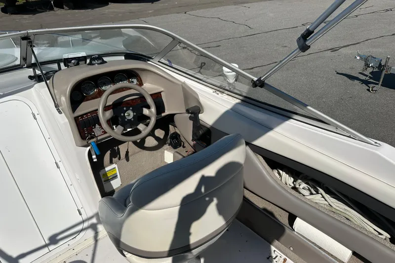 Slide: The Image of 2002 Four Winns 205 Sundowner boat cockpit with steering wheel and dashboard controls. - 10