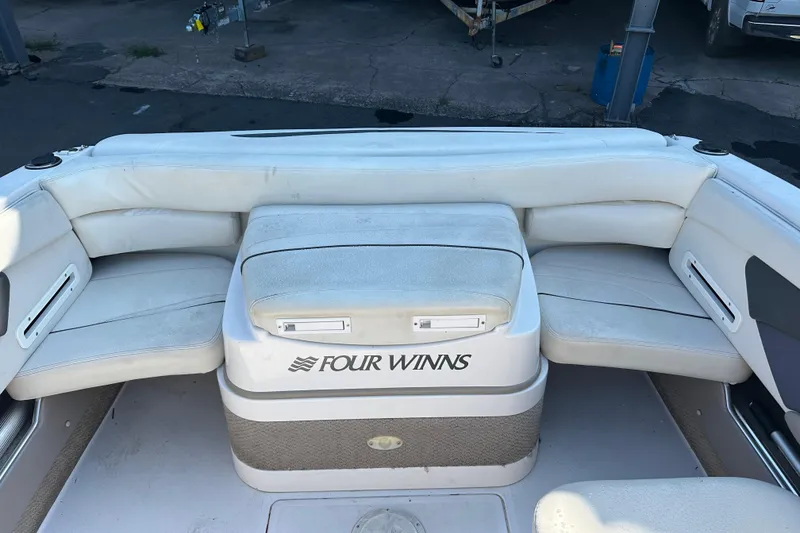 Slide: The Image of 2002 Four Winns 205 Sundowner boat interior with white seating and logo. - 6