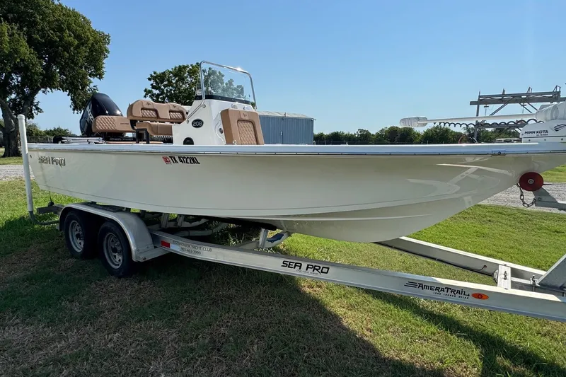 Slide: The Image of 2023 Sea Pro 208 Bay boat on trailer, parked on grass, sunny day. - 1