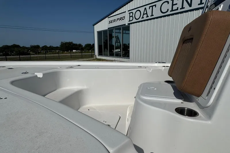 Slide: The Image of 2023 Sea Pro 208 Bay boat interior at dealership, featuring seating and storage. - 5