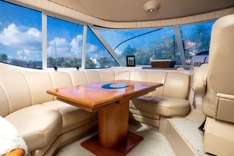 Slide: The Image of Luxurious interior of 2001 Cruisers Yachts 5000 Sedan Sport with leather seating and wooden table. - 11