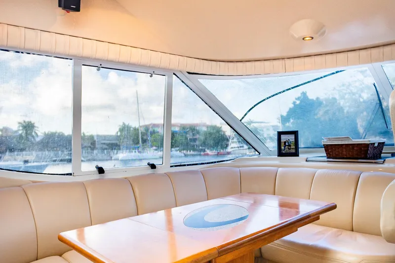 Slide: The Image of Interior of 2001 Cruisers Yachts 5000 Sedan Sport with leather seating and wooden table. - 12