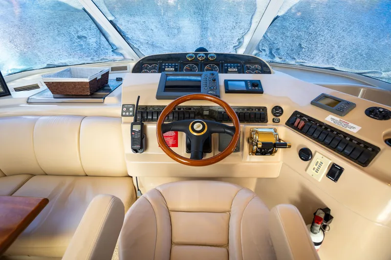 Slide: The Image of Interior helm of 2001 Cruisers Yachts 5000 Sedan Sport with leather seating and navigation controls. - 2