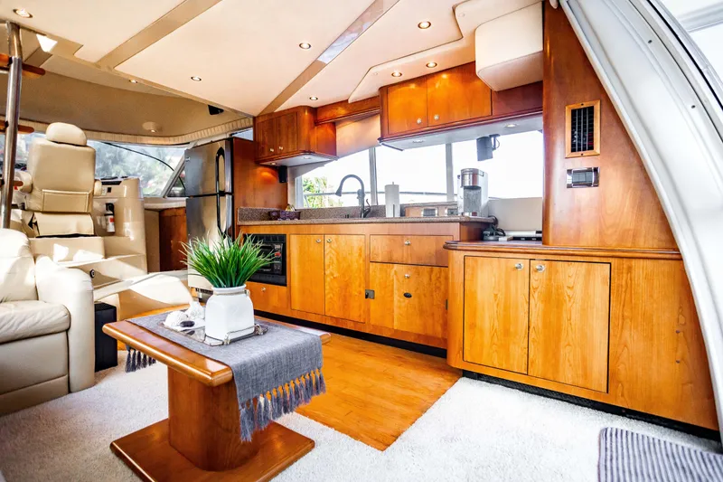 Slide: The Image of Luxurious interior of 2001 Cruisers Yachts 5000 Sedan Sport with elegant wood cabinetry. - 21