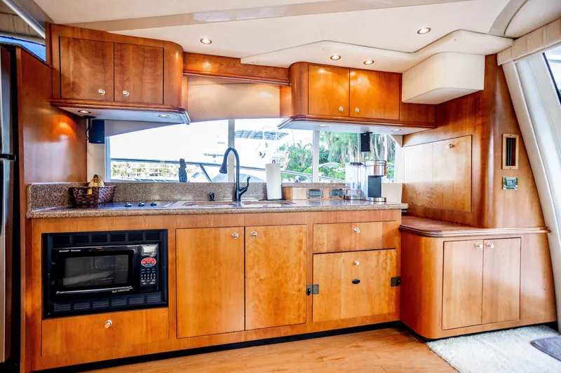 Slide: The Image of Luxurious 2001 Cruisers Yachts 5000 Sedan Sport kitchen with wood cabinetry and modern appliances. - 22