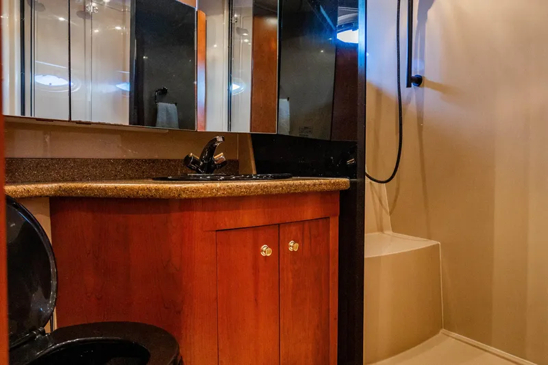 Slide: The Image of Luxurious bathroom in 2001 Cruisers Yachts 5000 Sedan Sport with wood cabinetry and modern fixtures. - 29