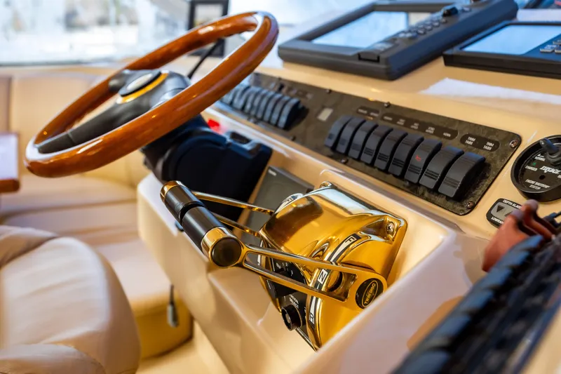 Slide: The Image of 2001 Cruisers Yachts 5000 Sedan Sport helm with wooden steering wheel and control panel. - 4