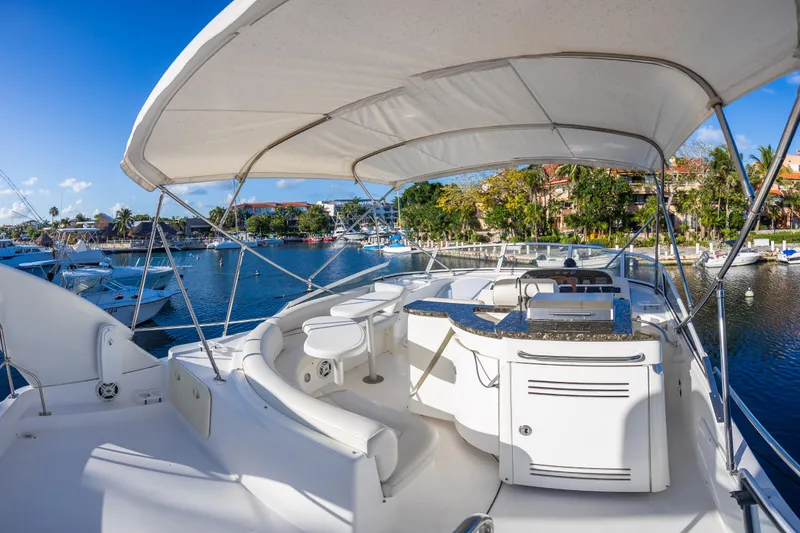 Slide: The Image of 2001 Cruisers Yachts 5000 Sedan Sport, spacious deck with seating, docked in sunny marina. - 40