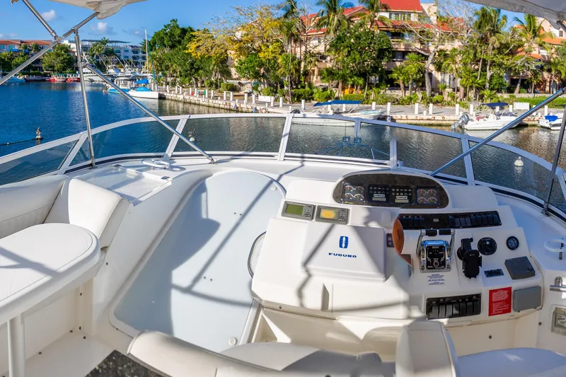 Slide: The Image of 2001 Cruisers Yachts 5000 Sedan Sport helm with waterfront view, featuring modern controls. - 45