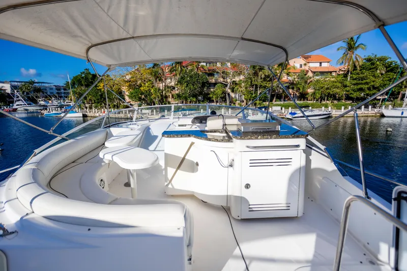 Slide: The Image of 2001 Cruisers Yachts 5000 Sedan Sport, spacious deck with seating, docked in a scenic marina. - 48