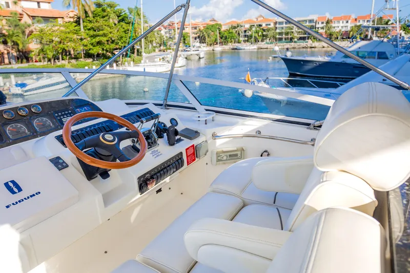 Slide: The Image of 2001 Cruisers Yachts 5000 Sedan Sport helm with luxurious seating and marina view. - 49