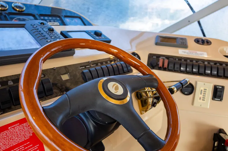 Slide: The Image of 2001 Cruisers Yachts 5000 Sedan Sport helm with wooden steering wheel and control panel. - 5