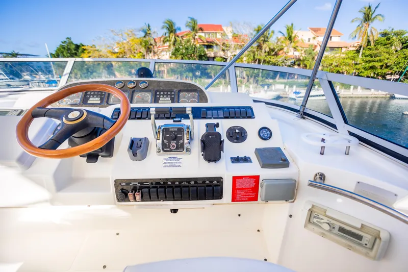 Slide: The Image of 2001 Cruisers Yachts 5000 Sedan Sport helm with wooden steering wheel and control panel. - 52