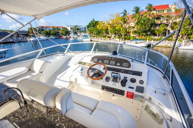 Slide: The Image of Cockpit view of 2001 Cruisers Yachts 5000 Sedan Sport, docked in a scenic marina. - 53