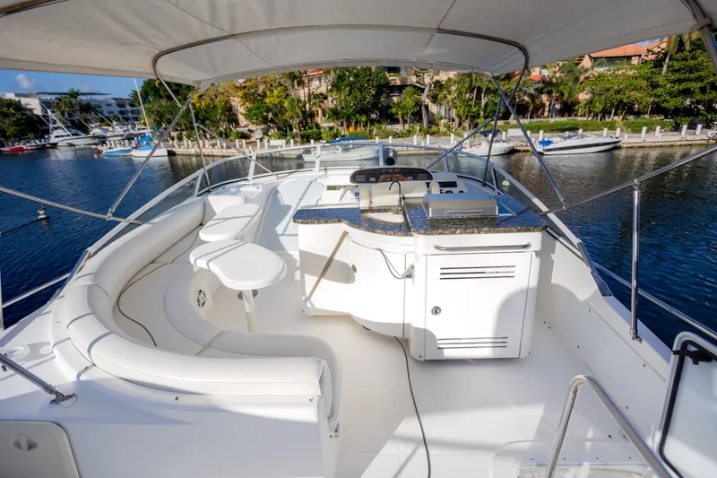 Slide: The Image of 2001 Cruisers Yachts 5000 Sedan Sport, spacious deck with seating and helm, docked by water. - 55