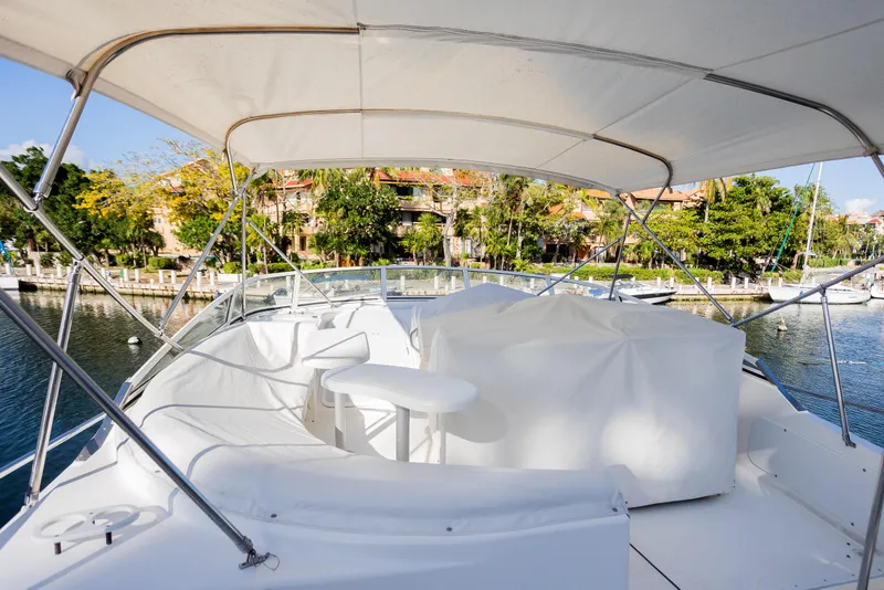 Slide: The Image of 2001 Cruisers Yachts 5000 Sedan Sport, docked with covered seating area, scenic marina view. - 58