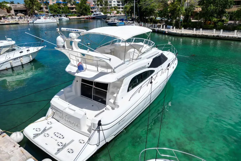 Slide: The Image of 2001 Cruisers Yachts 5000 Sedan Sport docked in clear turquoise water. - 59