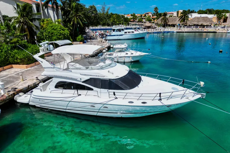 Slide: The Image of 2001 Cruisers Yachts 5000 Sedan Sport docked in a tropical marina setting. - 61